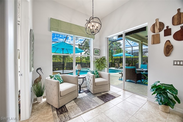 sitting room with a wealth of natural light, tile patterned floors, an inviting chandelier, and a sunroom