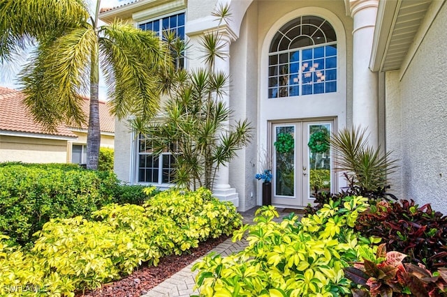 view of exterior entry with french doors and stucco siding