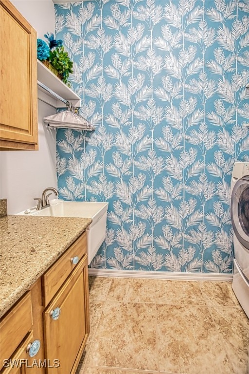 bathroom featuring vanity, washer / dryer, and baseboards