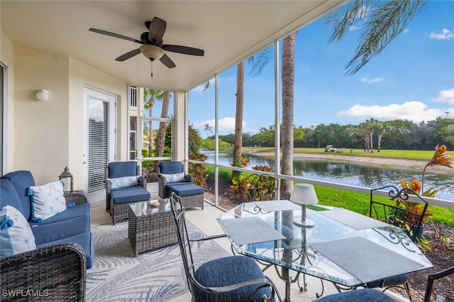 sunroom featuring a water view and ceiling fan