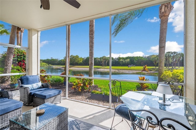 sunroom / solarium with a water view, a ceiling fan, and a wealth of natural light