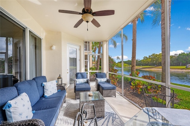 sunroom / solarium with a water view and a ceiling fan