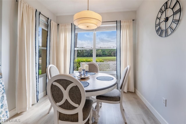 dining area featuring baseboards and light wood finished floors