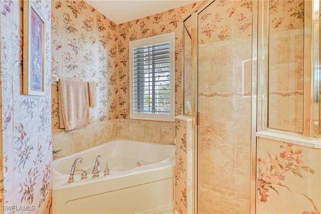 bathroom with wallpapered walls, a shower stall, and a bath