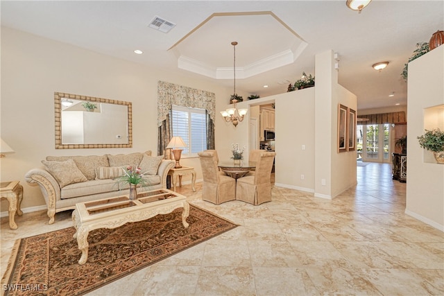 living area featuring a notable chandelier, visible vents, baseboards, and a tray ceiling