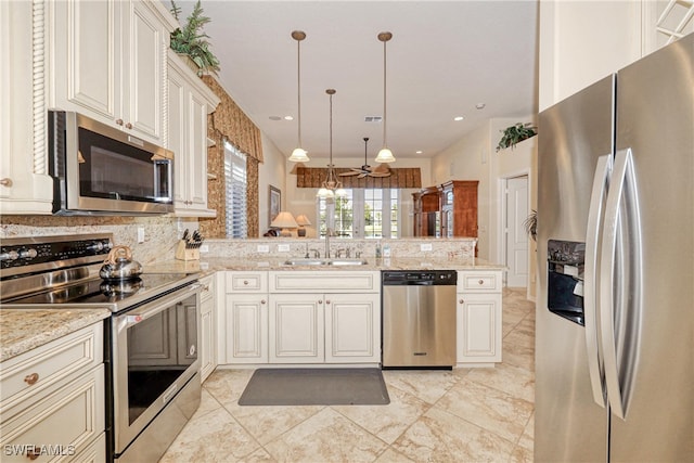 kitchen featuring visible vents, a peninsula, a sink, appliances with stainless steel finishes, and pendant lighting