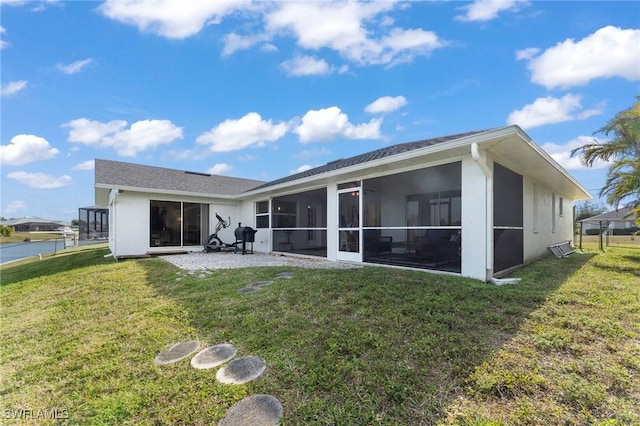 rear view of house featuring a sunroom, a yard, and fence