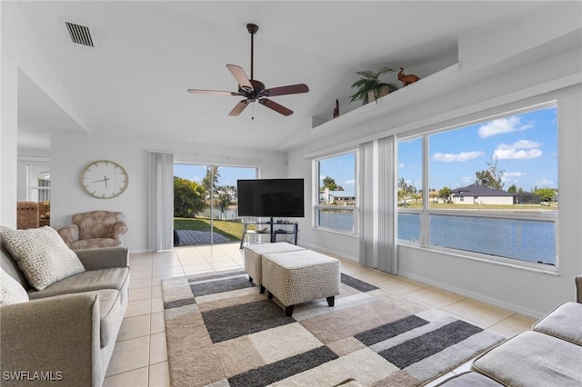 living area featuring visible vents, light tile patterned flooring, ceiling fan, vaulted ceiling, and baseboards