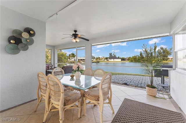 sunroom featuring a water view and ceiling fan