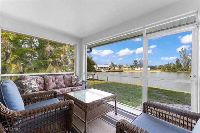 sunroom featuring a water view