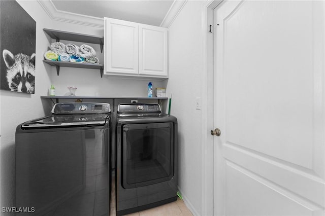 laundry room featuring cabinet space, baseboards, separate washer and dryer, and crown molding