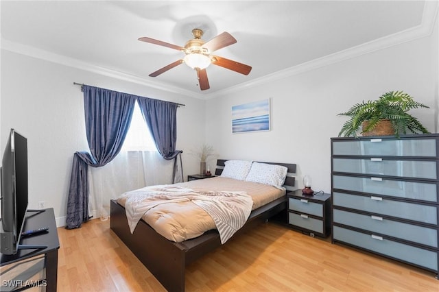 bedroom featuring light wood finished floors, ornamental molding, and a ceiling fan