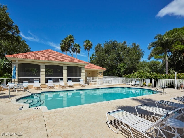 community pool featuring fence and a patio area