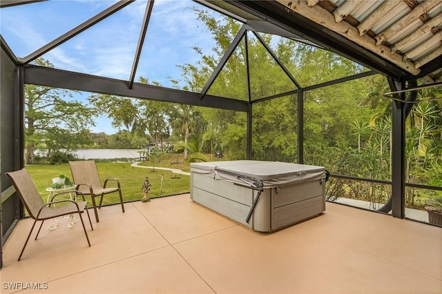 view of patio / terrace featuring a water view, a lanai, and a hot tub