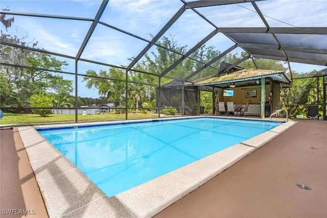 pool featuring glass enclosure and a patio