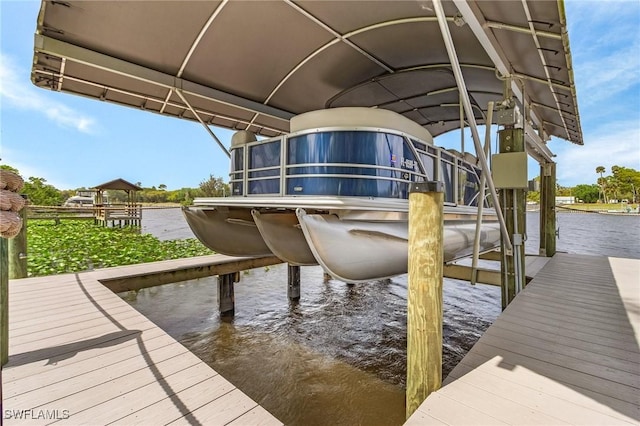 dock area with boat lift and a water view