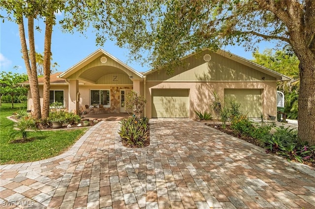 ranch-style home featuring stucco siding, decorative driveway, and a garage