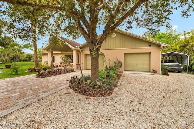 view of front facade with stucco siding, an attached garage, and decorative driveway