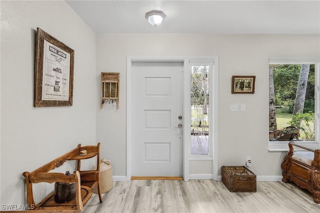 foyer entrance featuring light wood-style flooring and baseboards