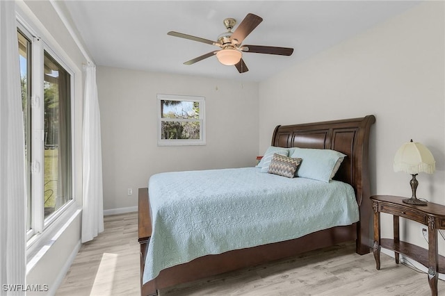 bedroom with ceiling fan, baseboards, and light wood-style flooring