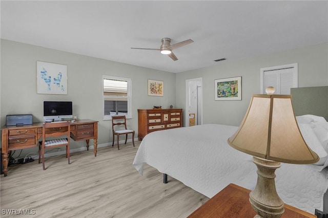 bedroom with a ceiling fan, wood finished floors, visible vents, and baseboards