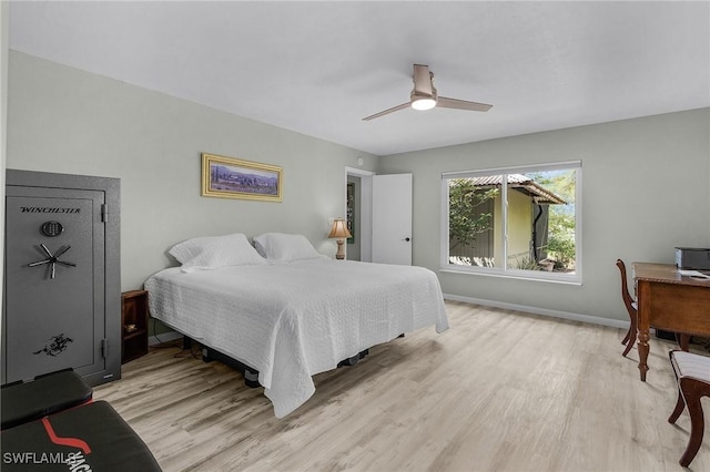 bedroom featuring light wood-style flooring, a ceiling fan, and baseboards