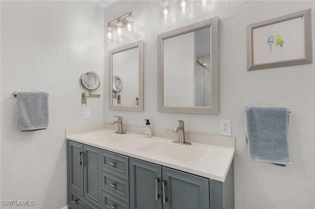 bathroom with a sink, double vanity, and a textured wall