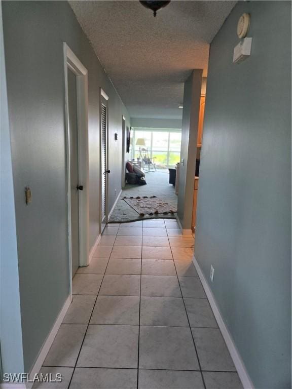 5910 Via Delray Blvd Unit B, Delray Beach, FL 33484 - corridor featuring light tile patterned floors, baseboards, and a textured ceiling