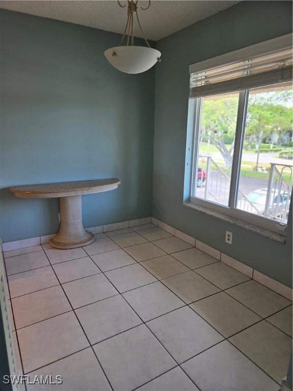 5910 Via Delray Blvd Unit B, Delray Beach, FL 33484 - unfurnished dining area with light tile patterned floors, baseboards, and a textured ceiling