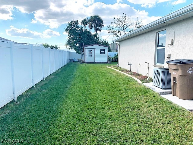 view of yard featuring a storage shed, fence, cooling unit, and an outdoor structure