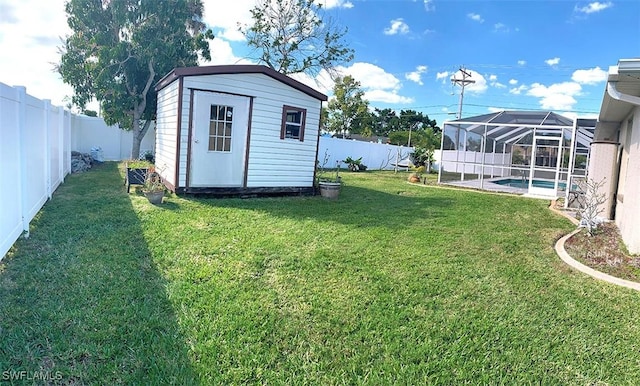 view of yard featuring a fenced in pool, a fenced backyard, an outbuilding, a lanai, and a storage unit