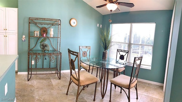 dining area featuring a ceiling fan, vaulted ceiling, and baseboards