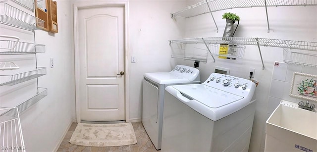 laundry area featuring laundry area, baseboards, and washer and clothes dryer