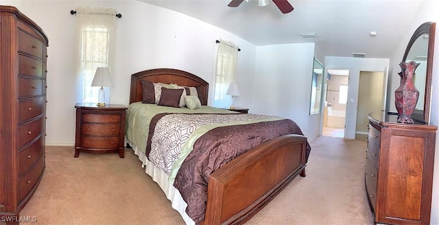 bedroom featuring ceiling fan, visible vents, ensuite bathroom, and light colored carpet