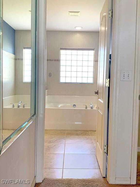 full bath featuring visible vents, a bath, and tile patterned floors