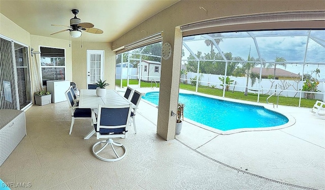 view of pool with a lanai, a patio area, a fenced backyard, and an outdoor structure