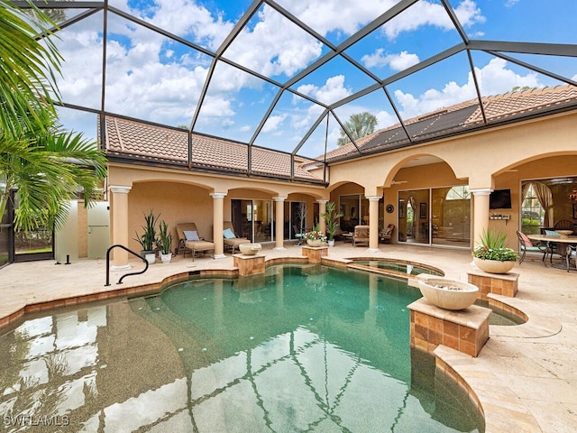 view of pool featuring a patio area, a lanai, and a pool with connected hot tub