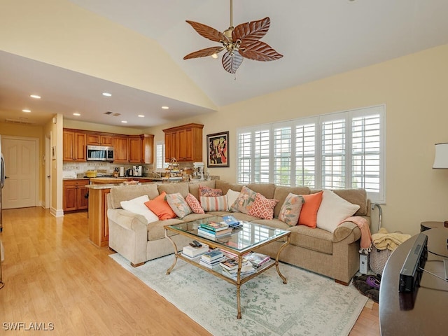 living area featuring ceiling fan, high vaulted ceiling, recessed lighting, and light wood-style floors