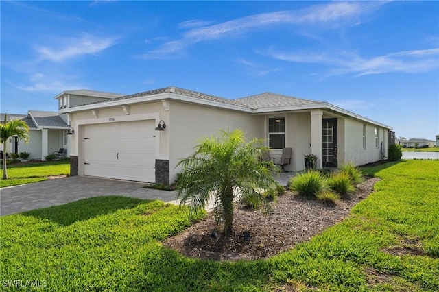 ranch-style house featuring a garage, a front yard, decorative driveway, and stucco siding