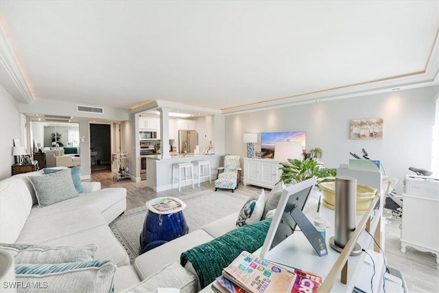 living area with light wood-style floors and visible vents