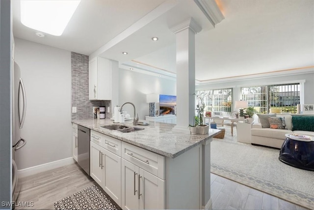 1085 Forest Lakes Dr Unit 8105, Naples, FL 34105 - kitchen with appliances with stainless steel finishes, a sink, light stone countertops, a peninsula, and ornate columns