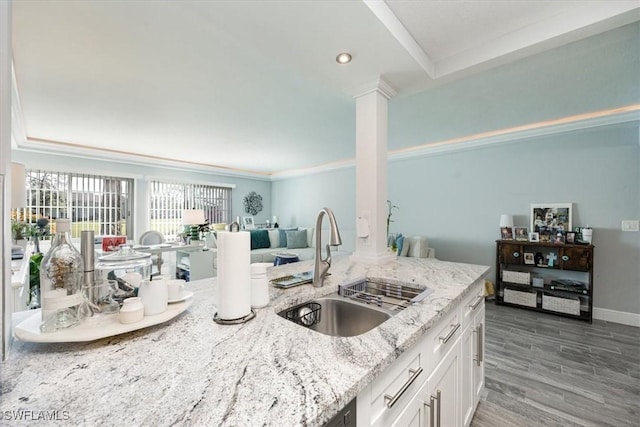 1085 Forest Lakes Dr Unit 8105, Naples, FL 34105 - kitchen featuring decorative columns, wood finished floors, light stone countertops, white cabinetry, and a sink