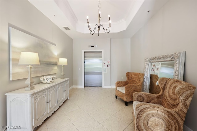 sitting room with a chandelier, visible vents, baseboards, a tray ceiling, and elevator