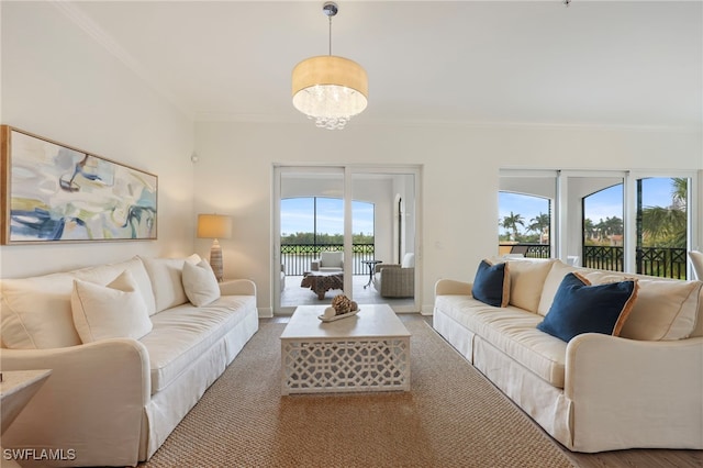 living room with a chandelier, ornamental molding, and baseboards