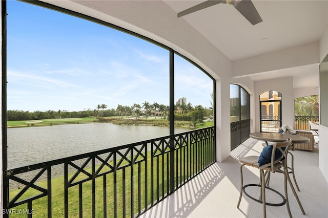 sunroom / solarium featuring plenty of natural light, a ceiling fan, and a water view