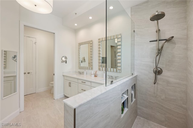 bathroom with baseboards, toilet, walk in shower, vanity, and recessed lighting