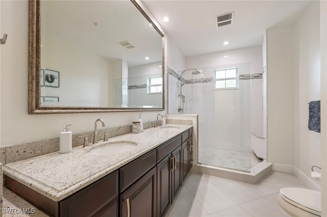 bathroom featuring toilet, a shower stall, visible vents, and a sink