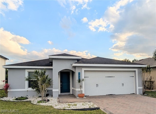 single story home with an attached garage, decorative driveway, and stucco siding