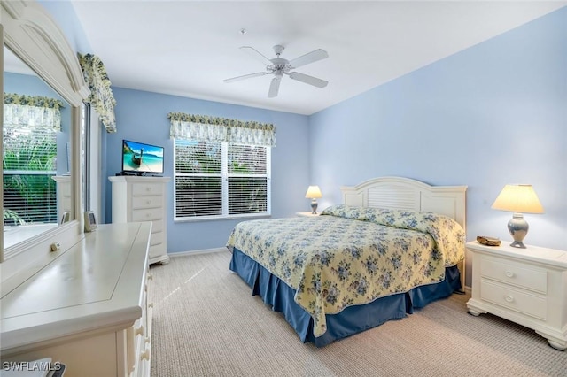 bedroom with ceiling fan, baseboards, and light colored carpet