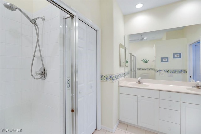 full bath with double vanity, a stall shower, a sink, and tile patterned floors